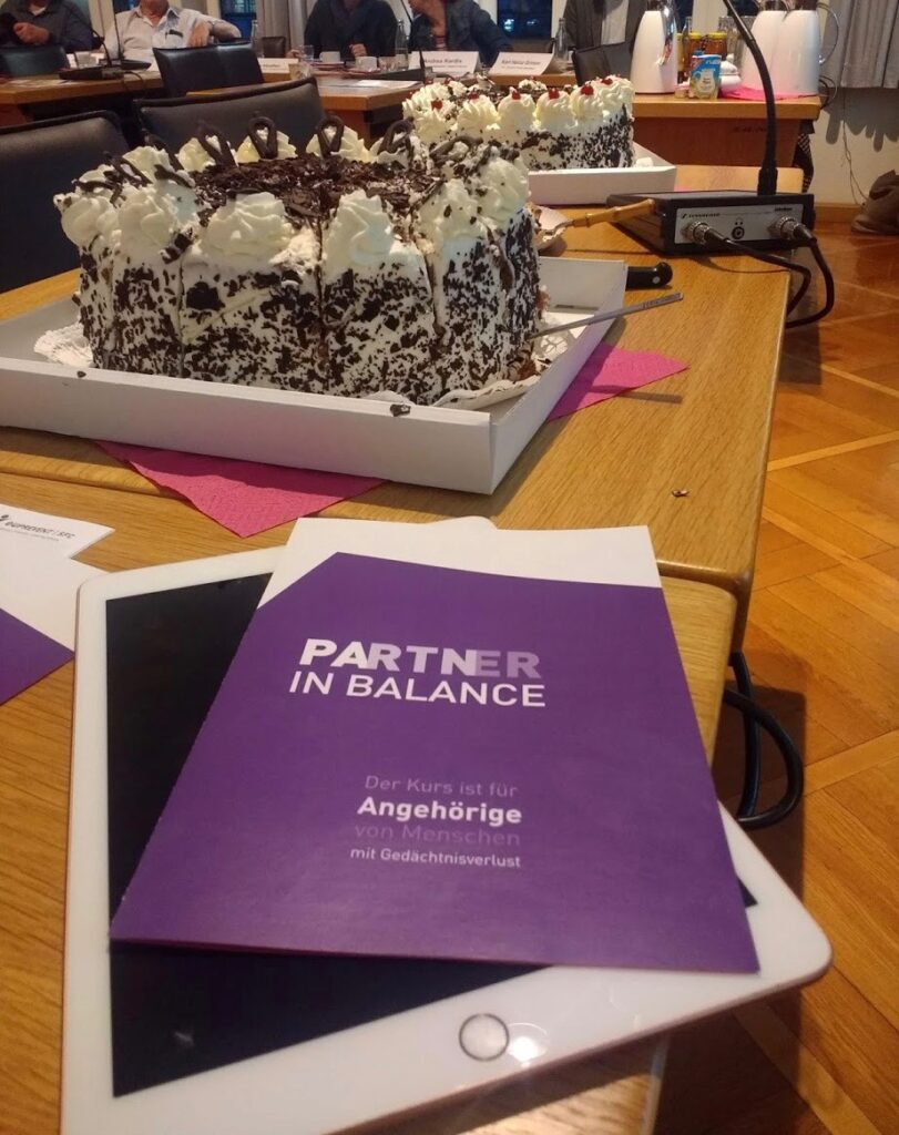 Photo of 'Partner in Balance' leaflet on an Ipad, and some cake